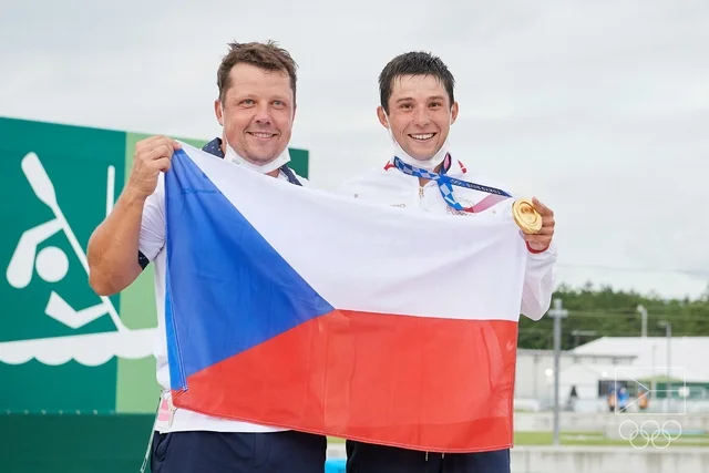 Čeští kanoisté s vlajkou a olympijským zlatým medailí.