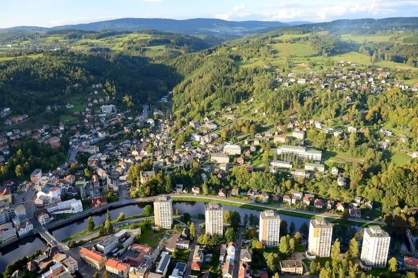 Vzdušný pohled na město Železný Brod v zelené kotlině.