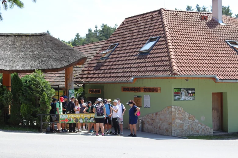 Skupina návštěvníků u vstupu do zoologické zahrady.