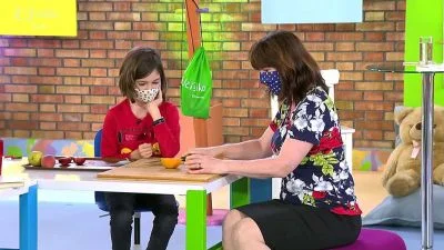 Žena s dítětem sedí u stolu v interiéru.